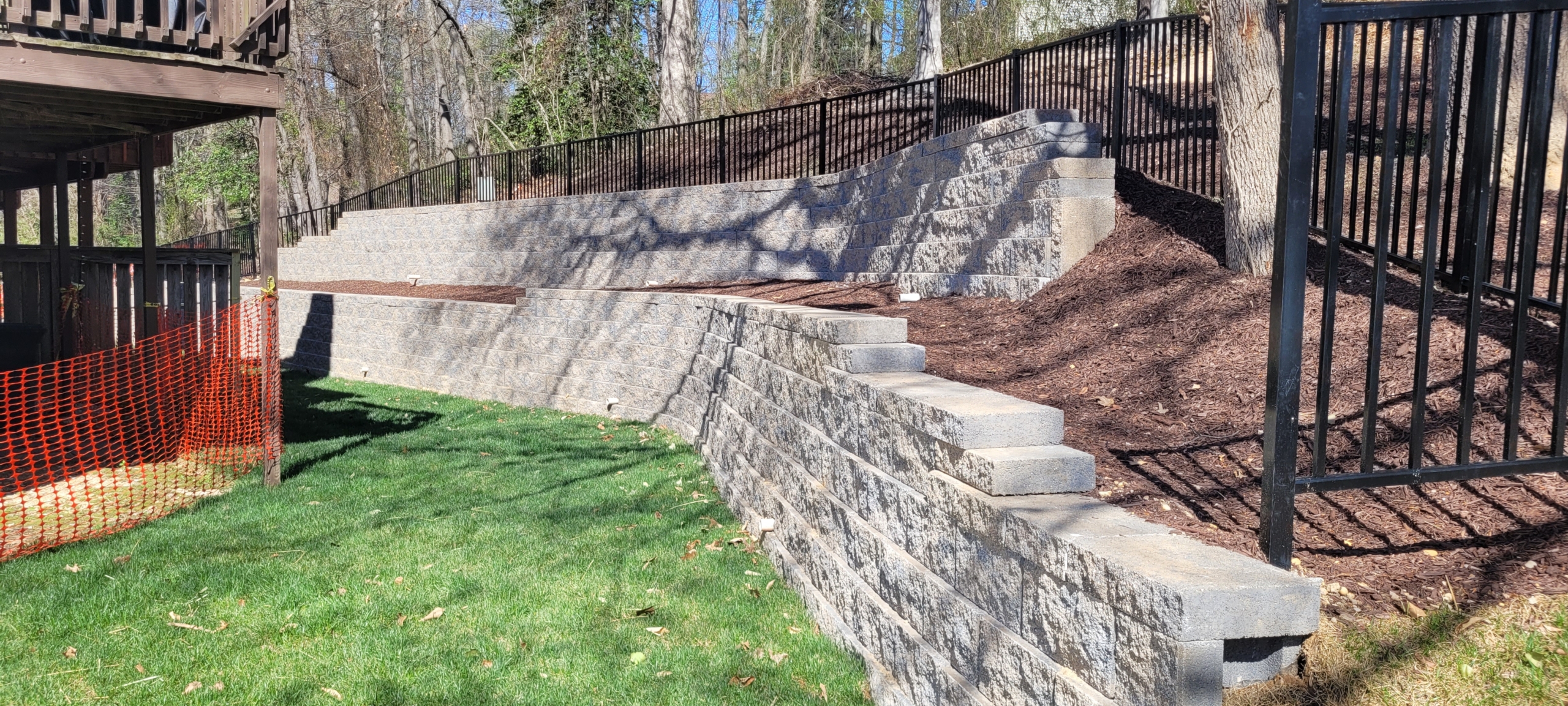 Segmental retaining wall stabilizes the slope behind a row of five houses.